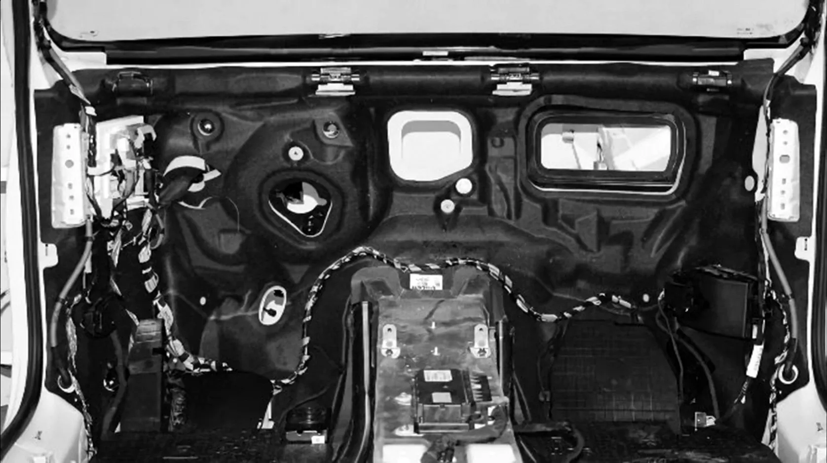 The black firewall insulation lining the front bulkhead of a car, seen from inside with the dashboard removed
