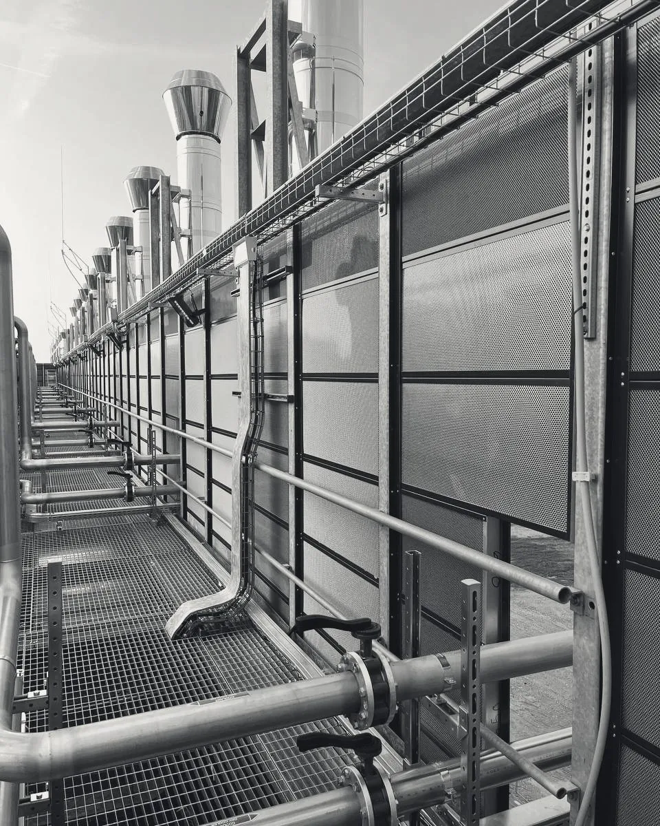 MetaSilencers along a data centre roof walkway, exhaust stacks above